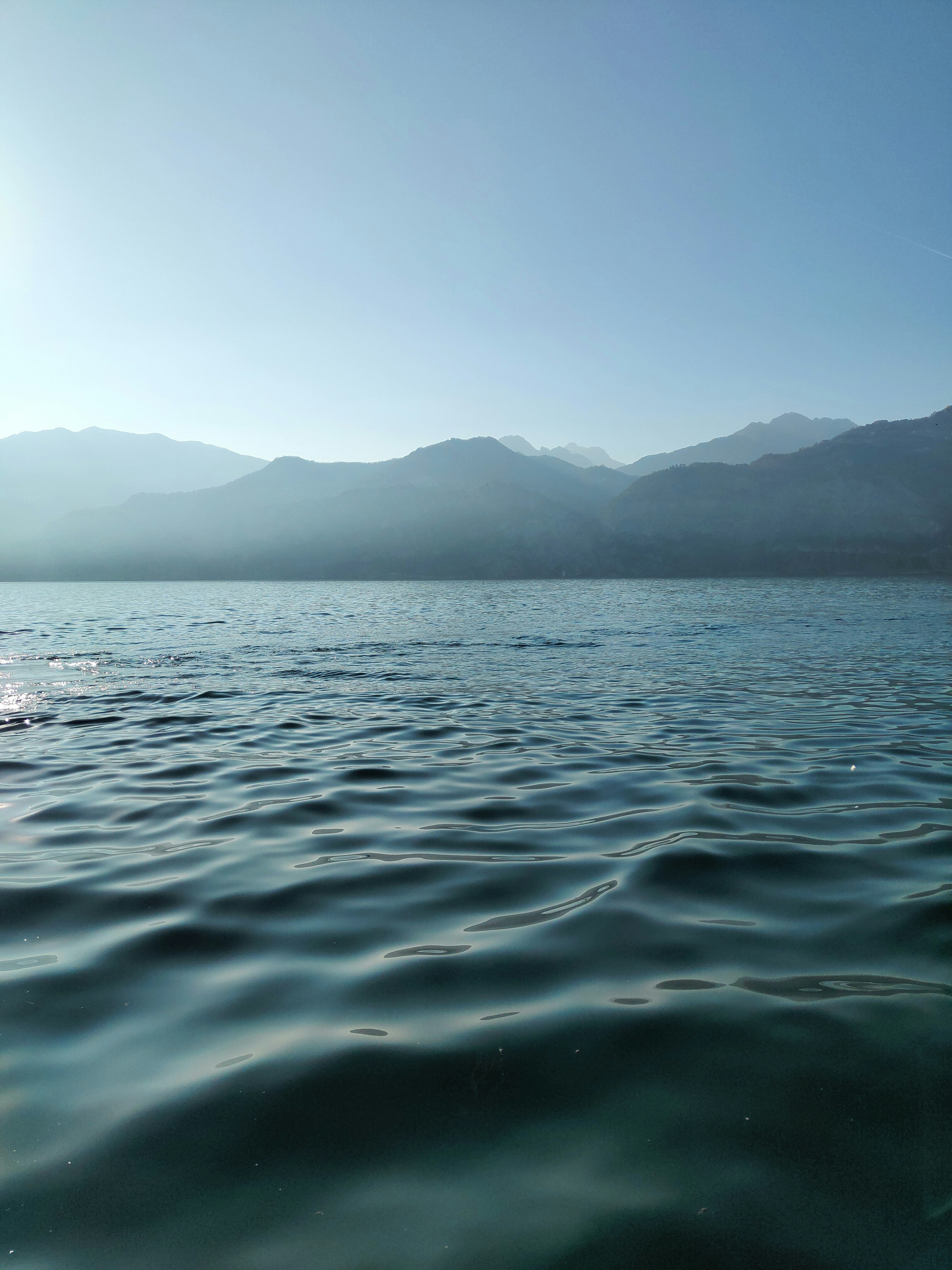 body of water near mountain during daytime